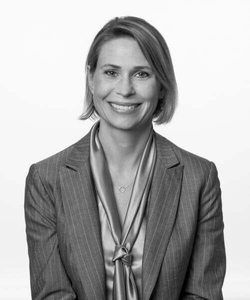 A woman in a suit and tie smiling for the camera.