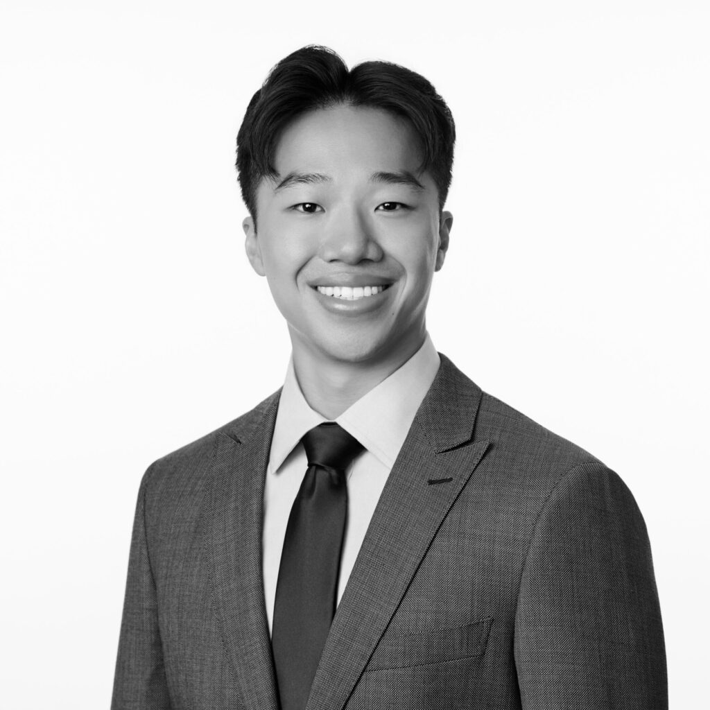 Young man in a suit smiling.